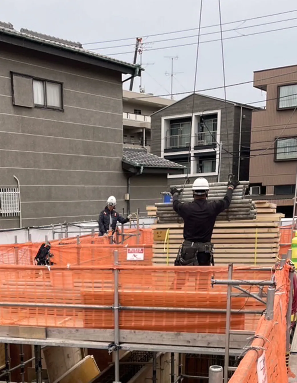 建設現場で資材を受け取る作業員たち