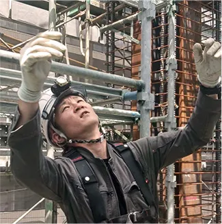 建設現場で上に向かって指示を出す作業員