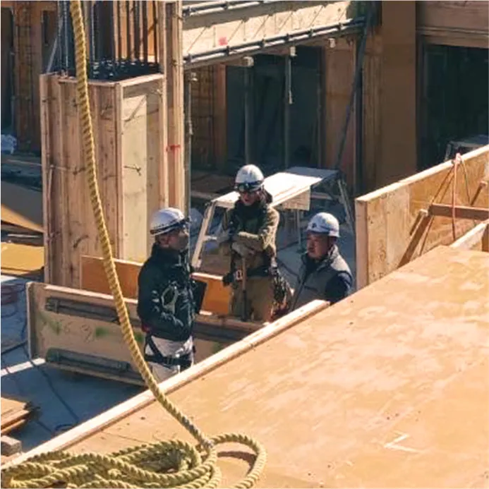 建設中の建物内部で話し合う作業員